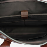 Burgunddy leather bag with a strap on a white background